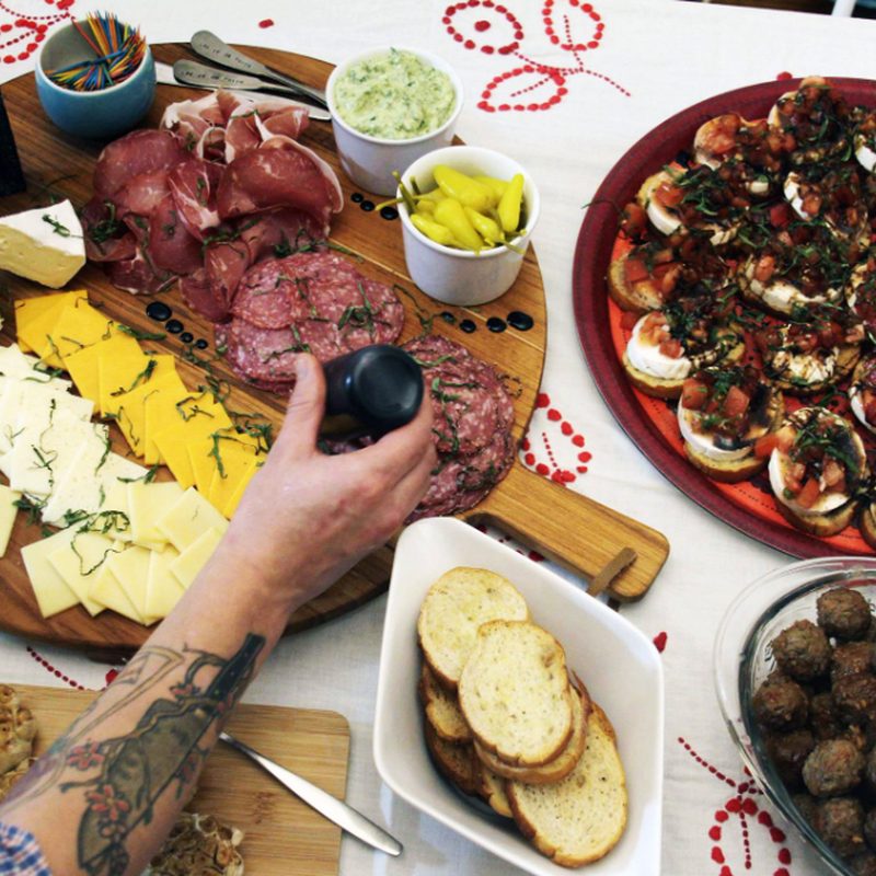 A charcuterie board with meats, cheese and fruit