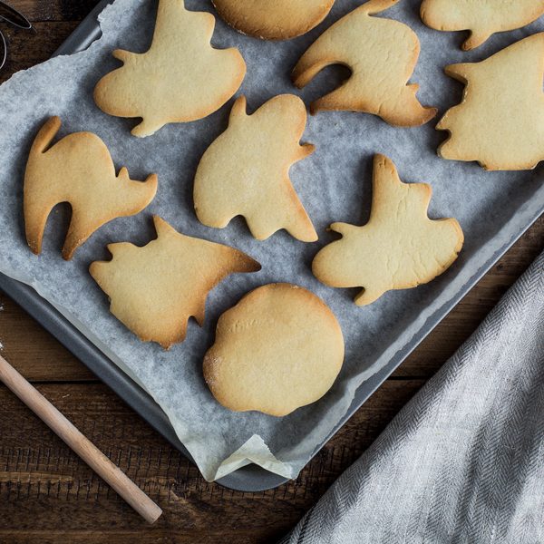 Ghost and cat shaped cookies on a baking tray